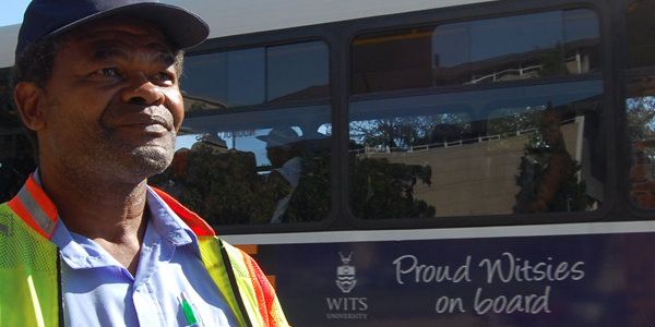 Parking attendant Michael Bodibe looks on as a Wits bus carrying students drives into campus.